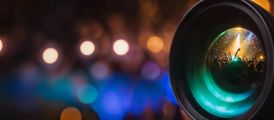 Camera lens reflecting a crowd at a music concert